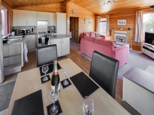 イフラクームにあるPine Lodgeのリビングルーム(ワイングラス付きのテーブル付)