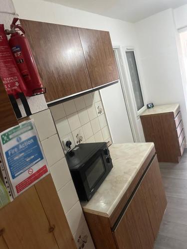 a small kitchen with a microwave on a counter at 2 Luxury Interconnecting Twin Rooms-Shared Space in Basildon