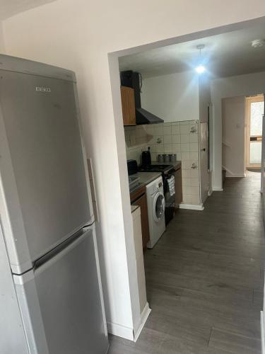 a kitchen with a refrigerator and a stove top oven at 2 Luxury Interconnecting Twin Rooms-Shared Space in Basildon