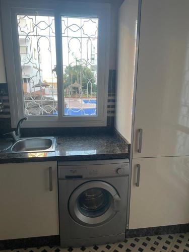 a kitchen with a washing machine and a window at Casa Amy in Mohammedia