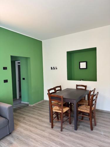 a dining room with green walls and a table and chairs at Ca' Buscion in Stresa