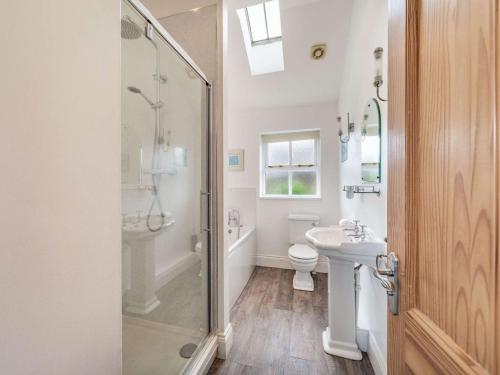 a bathroom with a shower and a toilet and a sink at 3 Bed in Longhoughton 88231 in Long Houghton