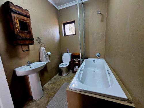 a bathroom with a sink and a tub and a toilet at Nawi Accommodation in Potchefstroom