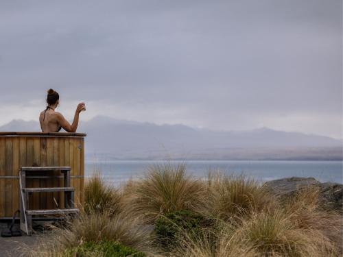 a man sitting on top of a wooden building at Mt Cook Lakeside Retreat in Lake Pukaki
