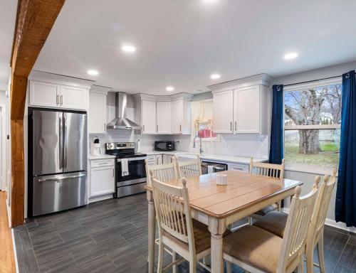a kitchen with white cabinets and a wooden table at Cozy Franklin Hideaway - For 5 in Franklin