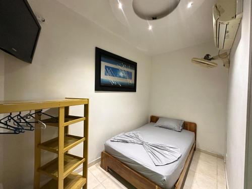 a small room with a bed and a television at Emporio Real Hotel in Yopal