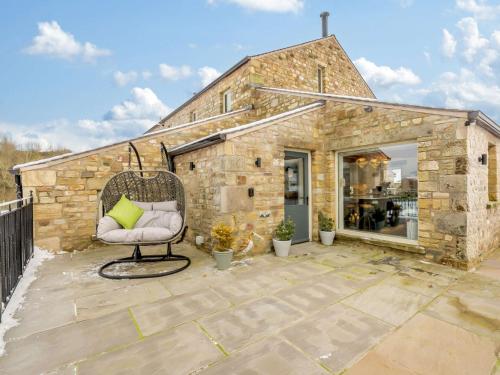 a stone building with a chair on a patio at 5 Bed in Ingleton 90546 in Burton in Lonsdale