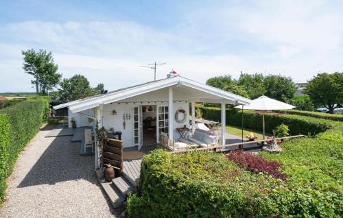 a small white building with an umbrella in a garden at Lovely Home In Kerteminde With Wifi in Kerteminde