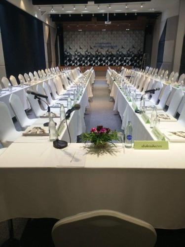 a large conference room with white tables and white chairs at The VELO'S Hotel and Pumptrack in Aranyaprathet