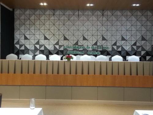 a waiting room with white chairs and a black and white wall at The VELO'S Hotel and Pumptrack in Aranyaprathet