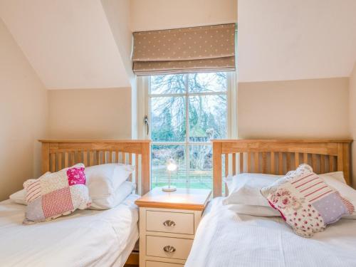 two twin beds in a bedroom with a window at 2 Bed in Nr Beadnell 77990 in Ellingham