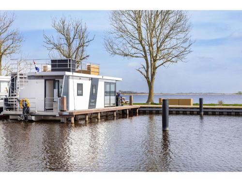 a houseboat is docked at a dock on the water at Unique vacation home in Offingawier