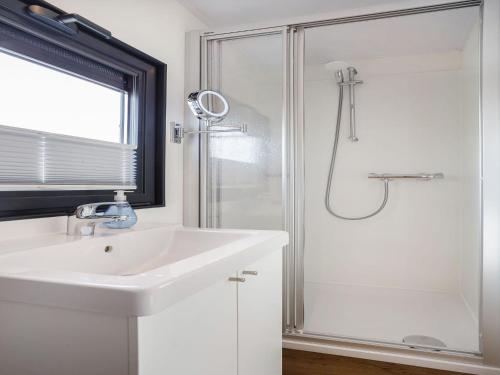 a white bathroom with a sink and a shower at Unique vacation home in Offingawier