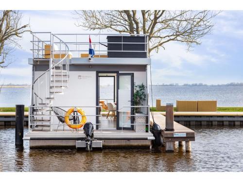 a small boat on the water with a dog on it at Unique vacation home in Offingawier