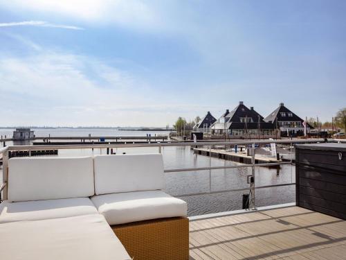 a balcony with a white couch and a dock at Unique vacation home in Offingawier