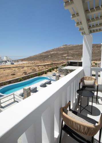 a balcony with two chairs and a swimming pool at Ventus Studios in Ano Mera