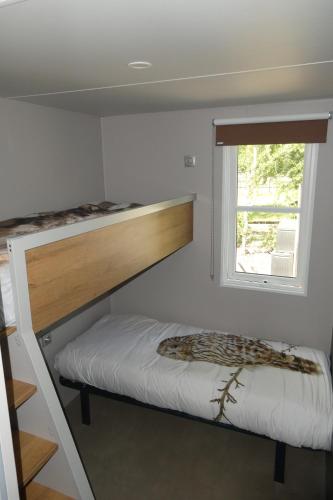 a bedroom with a bunk bed and a window at 3-persoons 4-persoons en 6-persoons chalet Drenthe in Hoogersmilde
