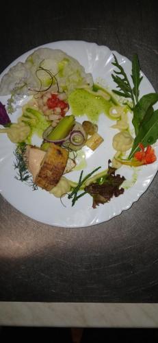 a white plate filled with vegetables on a table at Gasthaus Schmidt's in Neuhaldensleben