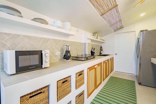 a kitchen with a microwave and a refrigerator at Kala Zoe Beachfront living in Moalboal