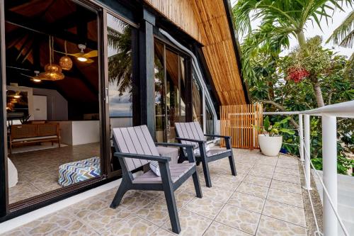 two chairs sitting on a patio with a table at Kala Zoe Beachfront living in Moalboal