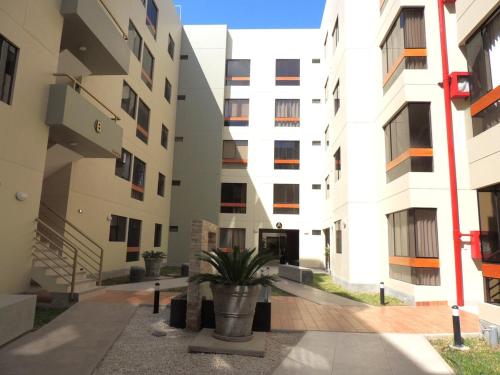 a courtyard of an apartment building with a potted plant at Elegante y comodo departamento en 1er piso, 3 camas 1 sofa cama in Chiclayo