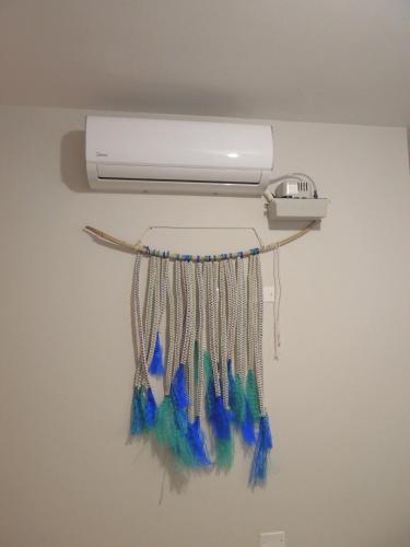 a light hanging on a wall with blue and green tassels at Elegante y comodo departamento en 1er piso, 3 camas 1 sofa cama in Chiclayo