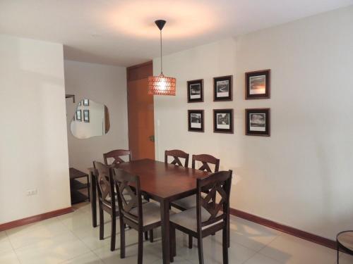a dining room with a wooden table and chairs at Elegante y comodo departamento en 1er piso, 3 camas 1 sofa cama in Chiclayo