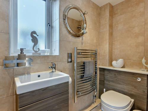 a bathroom with a sink and a toilet and a mirror at 2 Bed in Westward Ho 45753 in Northam