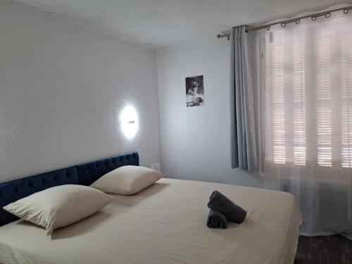 - une chambre avec un lit doté d'une tête de lit bleue et d'une fenêtre dans l'établissement Appartement 2 chambres à Cannes, à Cannes