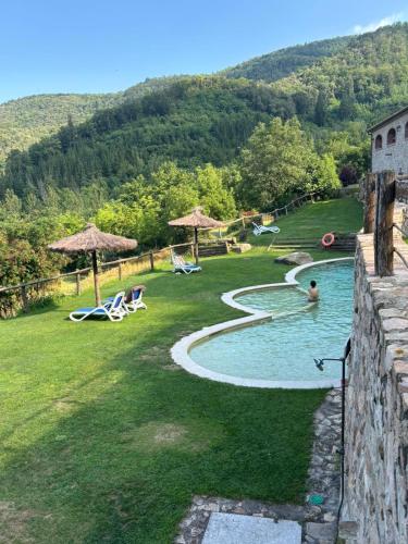 a backyard with a swimming pool and chairs and a pool at Mas Vilar, relax, nature and slow Exclusive Only 6 rooms in Arbúcies