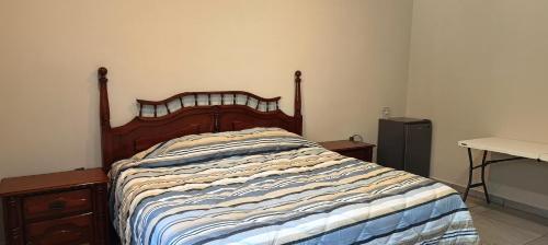 a bed with a wooden headboard in a bedroom at Habitación Arándano in Ciudad Guzmán