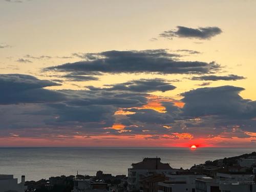 a sunset over the ocean with a city at Apartments Radosevic in Ulcinj