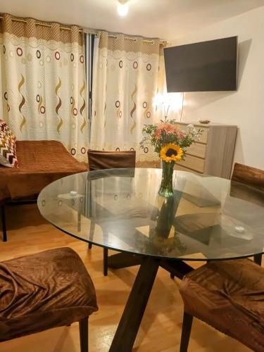 a glass table with a vase of flowers in a living room at Suite vista al mar San Miguel in Lima