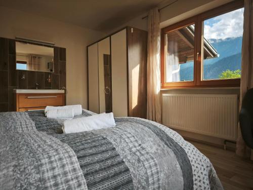 a bedroom with two beds and a large window at Sport Apartments Tirol in Umhausen