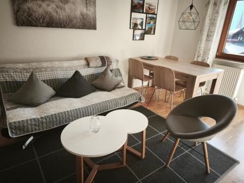a living room with a couch and a table and chairs at Sport Apartments Tirol in Umhausen