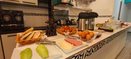 Una encimera de cocina con queso, frutas y verduras. en Hotel La Florida, en Cusco