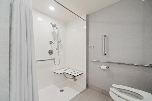 a white bathroom with a shower and a toilet at Crowne Plaza Lansing by IHG in Lansing