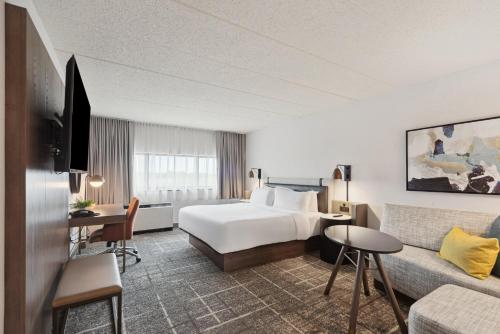a hotel room with a bed and a couch at Crowne Plaza Lansing by IHG in Lansing