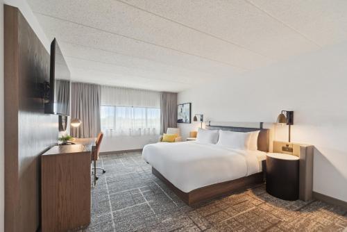 a hotel room with a large bed and a desk at Crowne Plaza Lansing by IHG in Lansing