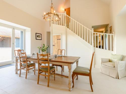 a dining room with a table and chairs and a staircase at 2 Bed in Tisbury 78165 in Tisbury