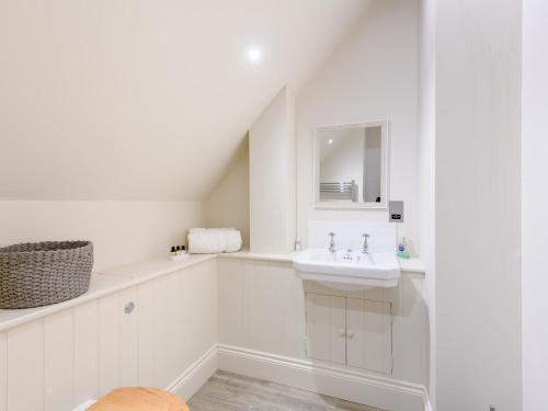 a white bathroom with a sink and a mirror at 2 Bed in Tisbury 78165 in Tisbury
