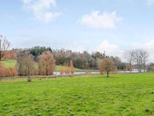 a field with a river and trees in the background at 2 Bed in Tisbury 78165 in Tisbury