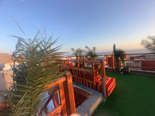 a balcony with tables and a plant on a roof at Atalanta Surf House in Imsouane