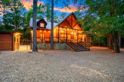 a large house with lights on the side of it at After the Sunset 1-Level 5BR Pool - Arcade in Broken Bow