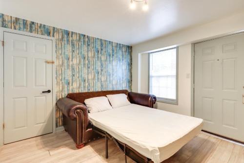 Cama en habitación con sofá y ventana en Easy Highway Access Low-Key Norcross Studio!, en Norcross