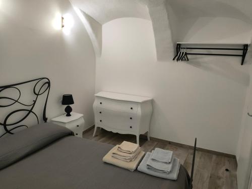 Un dormitorio con una cama y un escritorio con toallas. en Appartamento Luca, en Tiarno di Sotto