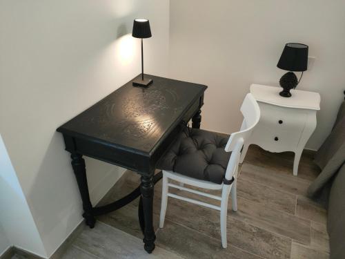 un escritorio negro con una silla y una lámpara. en Appartamento Luca, en Tiarno di Sotto