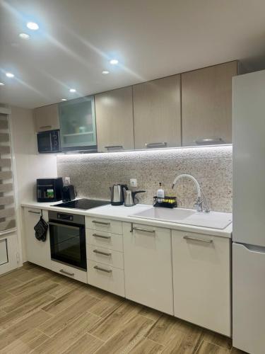a kitchen with white cabinets and a sink at Lucky Home Chios in Chios