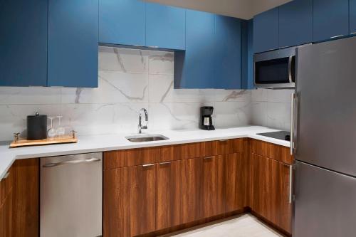 a kitchen with blue cabinets and a sink and a refrigerator at Residence Inn by Marriott Washington Downtown/Convention Center in Washington