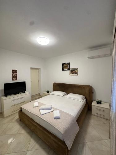 una camera da letto con un letto e una TV a schermo piatto di Ina's apartment a Sarandë